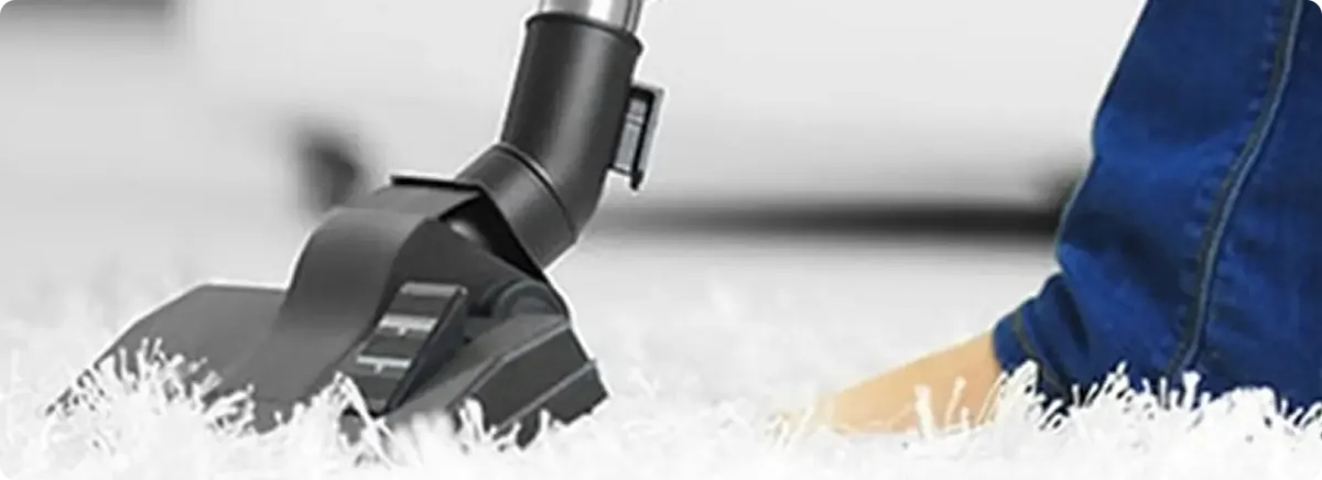 Close-up of a professional vacuuming a white carpet in Alcoa.